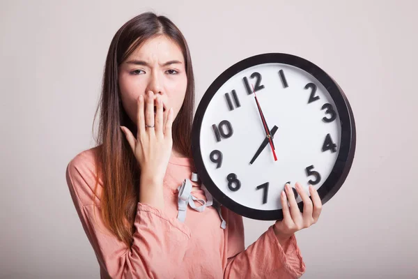 Sonnolenta giovane donna asiatica con un orologio al mattino . — Foto Stock