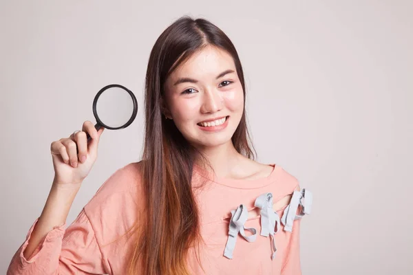 Jonge Aziatische vrouw met een vergrootglas. — Stockfoto