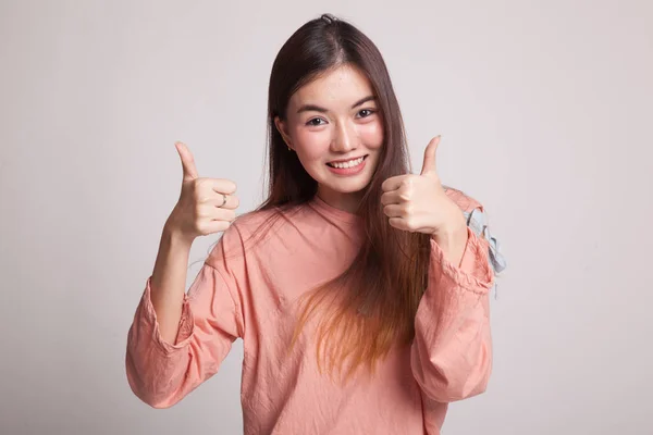 Junge asiatische Frau zeigen zwei Daumen nach oben. — Stockfoto