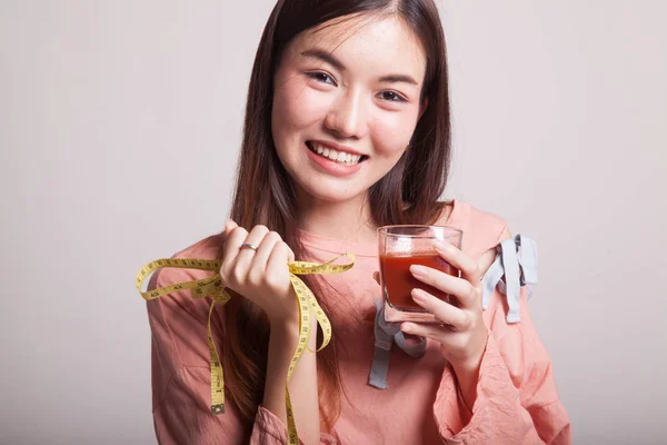 Ázsiai nő paradicsomlé és mérőszalag. — Stock Fotó