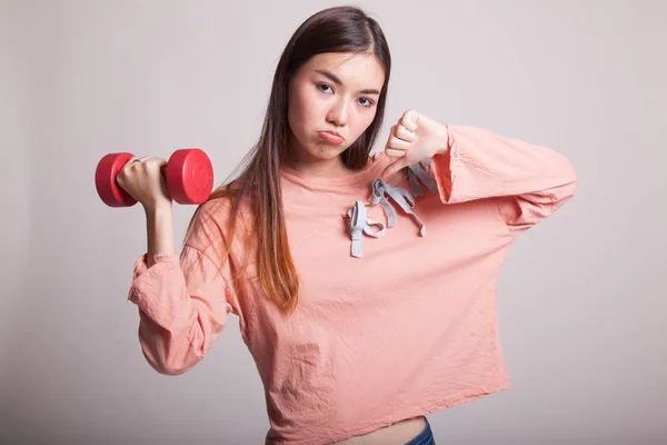 Infeliz asiático mujer pulgares abajo con dumbbells . — Foto de Stock