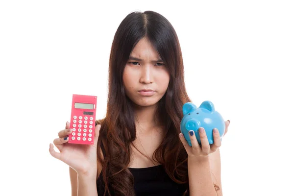 Unhappy Asian woman with calculator and piggy bank. — Stock Photo, Image