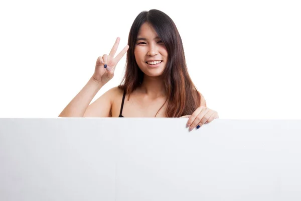 Mujer asiática joven muestra signo de victoria con signo en blanco . — Foto de Stock