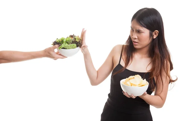 Jonge Aziatische vrouw met aardappel chips nee zeggen tegen salade. — Stockfoto