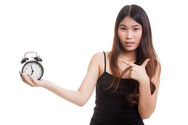 Junge asiatische Frau zeigt auf eine Uhr. — Stockfoto