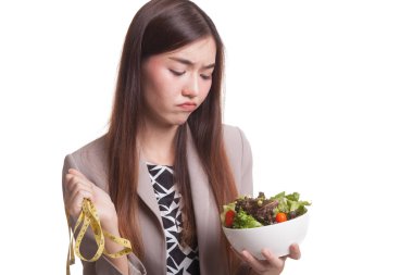 Ölçme bant ve salata ile mutsuz Asyalı kadın.