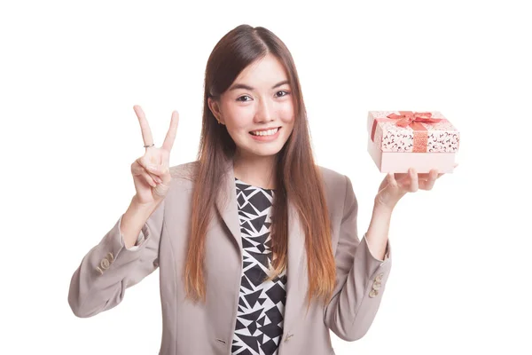 Mujer asiática joven muestra signo de victoria con una caja de regalo . —  Fotos de Stock