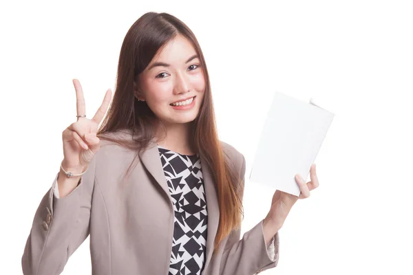 Junge asiatische Frau zeigt Siegerzeichen mit einem Buch. — Stockfoto