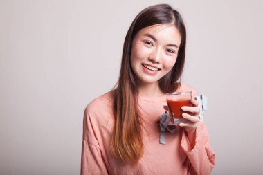 Genç Asyalı kadın içki domates suyu.