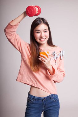 Genç Asyalı kadın dumbbell içki portakal suyu ile.