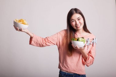 Patates kızartması ve salata ile genç Asyalı kadın.