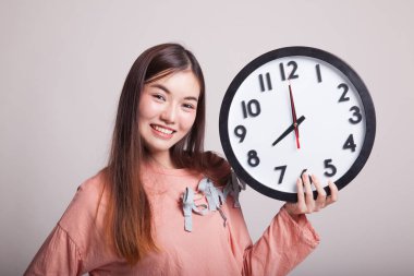 Saati olan genç Asyalı kadın..