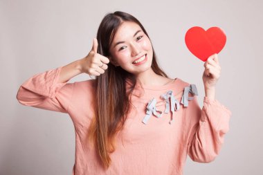 Asyalı kadın başparmak yukarıya ile kırmızı kalp.
