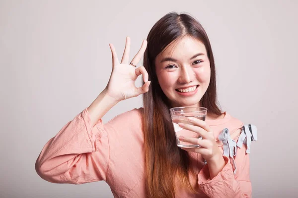 Giovane donna asiatica mostra OK con un bicchiere di acqua potabile . — Foto Stock