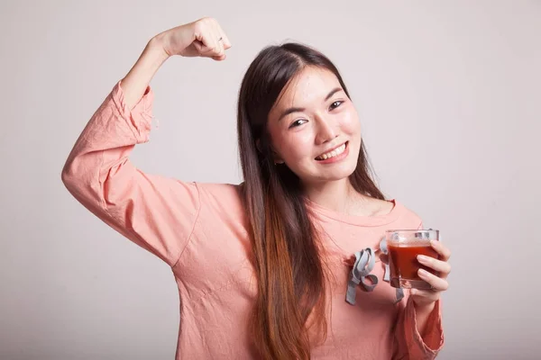 Sterke gezonde Aziatische vrouw met tomatensap. — Stockfoto