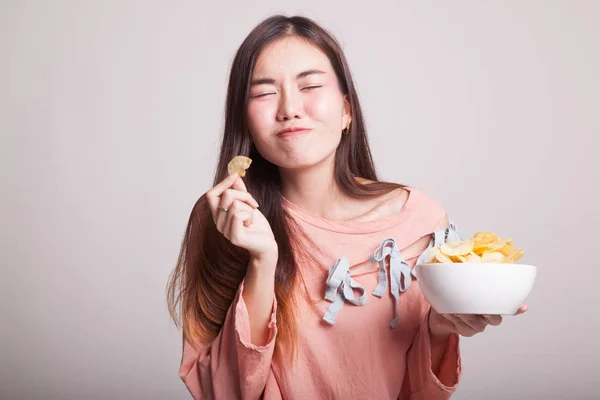 Jonge Aziatische vrouw potato chips eten. — Stockfoto