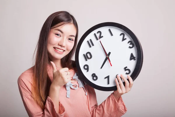 Joven mujer asiática pulgares arriba con un reloj . —  Fotos de Stock