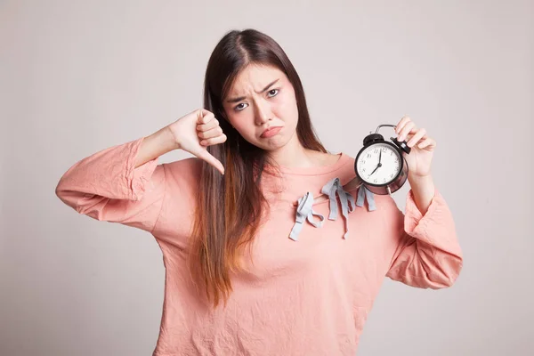 Jeune femme asiatique pouces vers le bas avec une horloge . — Photo