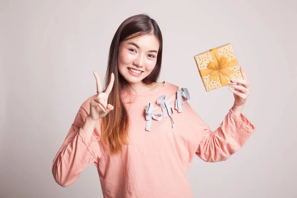 Aziatische vrouw Toon overwinning bord met een geschenkdoos. — Stockfoto