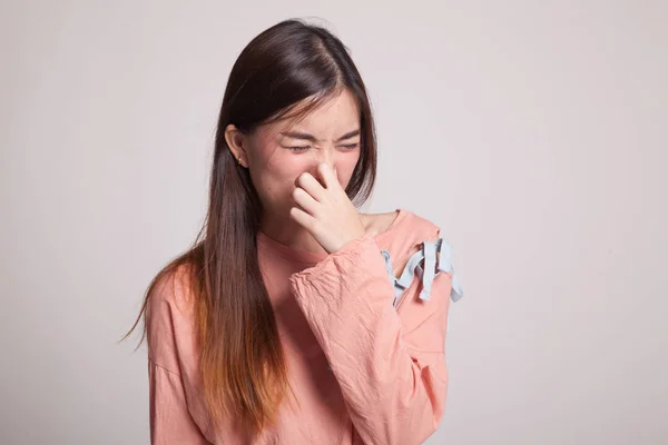 Joven asiática sosteniendo su nariz debido a un mal olor . — Foto de Stock