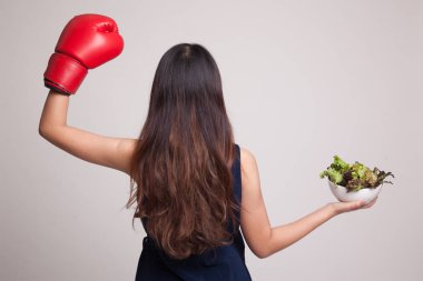 Genç Asyalı kadın boks eldiven ve salata ile.