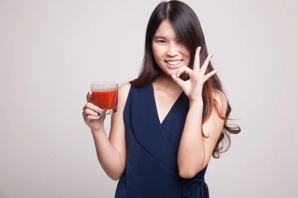Ung asiatisk kvinna show Ok med tomatjuice. — Stockfoto