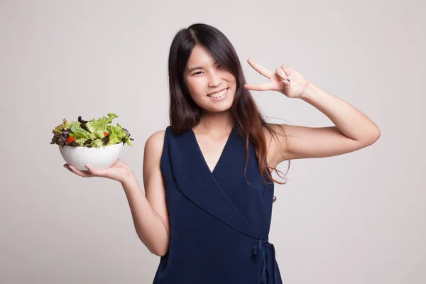 Friska asiatisk kvinna Visa seger tecken med sallad. — Stockfoto