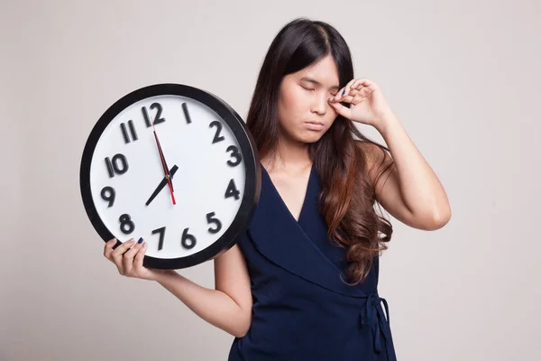 Sleepy joven asiática mujer con un reloj en la mañana . — Foto de Stock