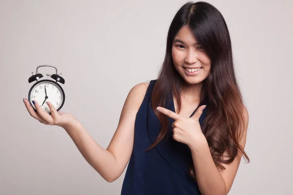 Joven asiática mujer punto a un reloj . — Foto de Stock