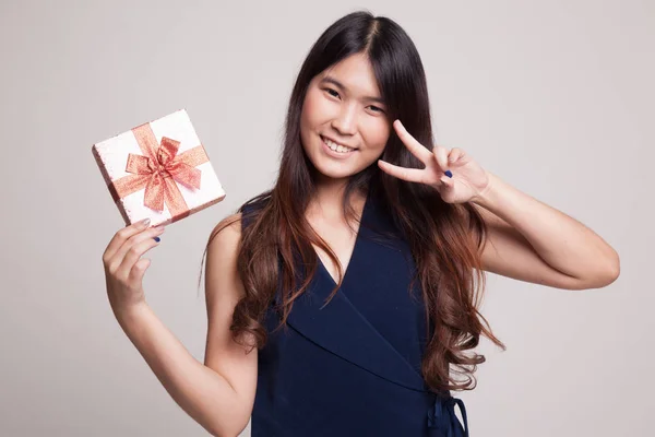 Азиатка показывает знак победы с подарочной коробкой . — стоковое фото