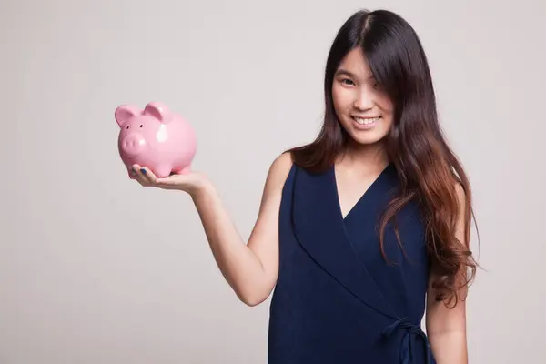 Young Asian woman with a pig coin bank. — Stock Photo, Image