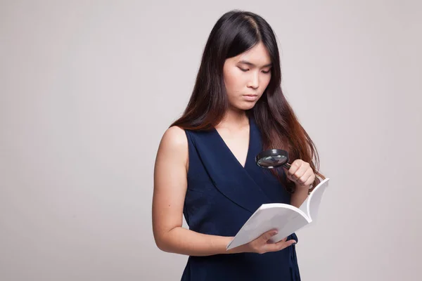 Mujer asiática con un libro y lupa . —  Fotos de Stock