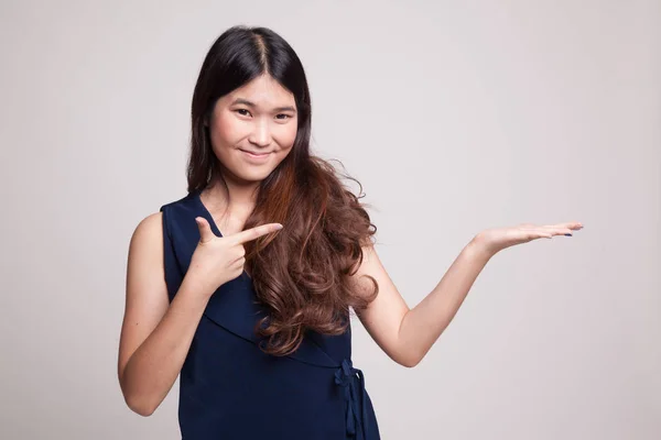 Beautiful young Asian woman point to palm hand. — Stock Photo, Image