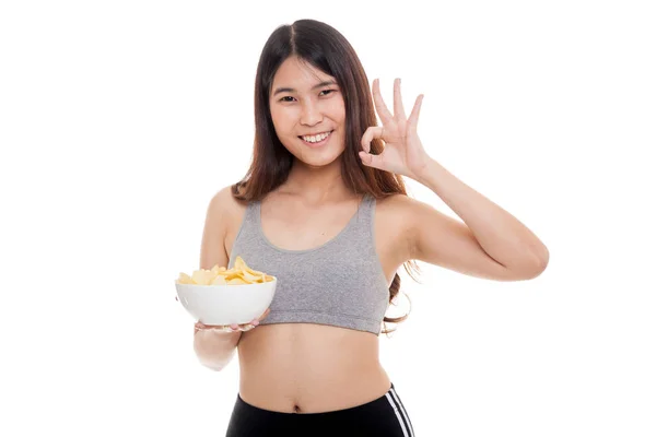 Hermosa chica sana asiática comer papas fritas mostrar OK signo . —  Fotos de Stock
