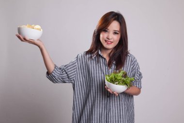 Patates kızartması ve salata ile genç Asyalı kadın.