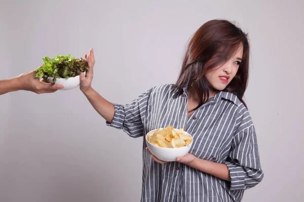 Ung asiatisk kvinna med potatischips säga nej till sallad. — Stockfoto