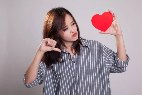 Asian woman thumbs down with red heart.