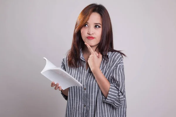 Giovane donna asiatica con un libro sta pensando . — Foto Stock