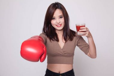 Domates suyu ve Boks eldiveni ile genç Asyalı kadın.