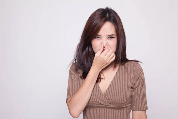 Jonge Aziatische vrouw met haar neus vanwege een slechte geur. — Stockfoto