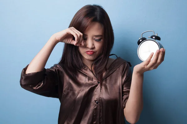 Sleepy joven asiática mujer con un reloj en la mañana . —  Fotos de Stock