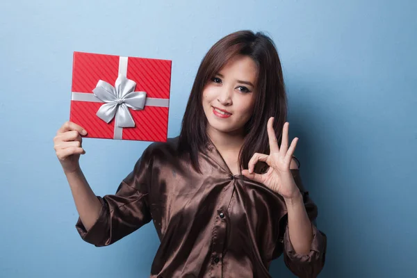 Young Asian woman show OK with a gift box. — Stock Photo, Image