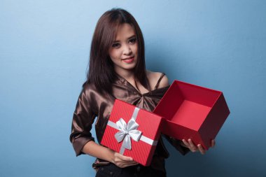 Genç Asyalı kadın açık bir altın hediye kutusu.