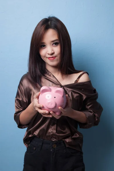 Young Asian woman with a pig coin bank. — Stock Photo, Image