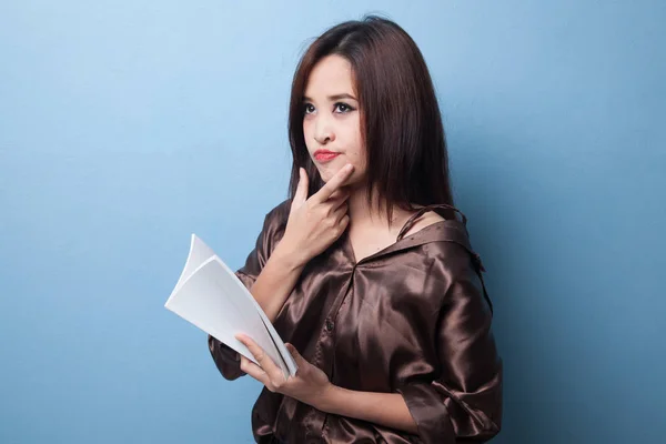 Ung asiatisk kvinna med en bok tänker. — Stockfoto