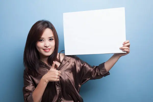 Jonge Aziatische vrouw opdagen duimen met witte leeg bord. — Stockfoto