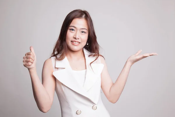 Beautiful young Asian woman show palm hand and thumbs up. — Stock Photo, Image