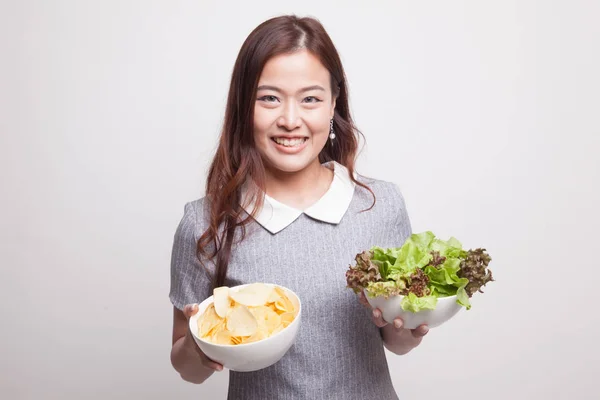 Jonge Aziatische vrouw met aardappel frites en salade. — Stockfoto