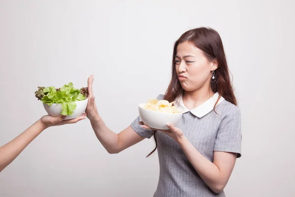 Jonge Aziatische vrouw met salade nee zeggen tegen potato chips. — Stockfoto