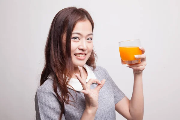 Giovane asiatico donna spettacolo OK bere arancia succo . — Foto Stock